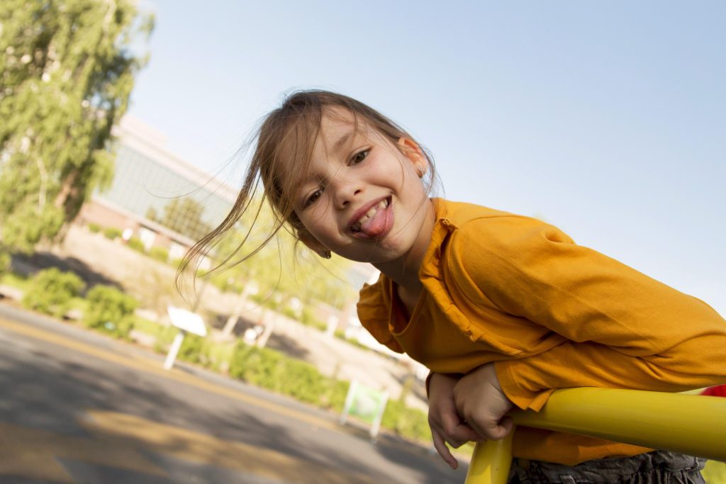 A young girls plays on playground equipment,