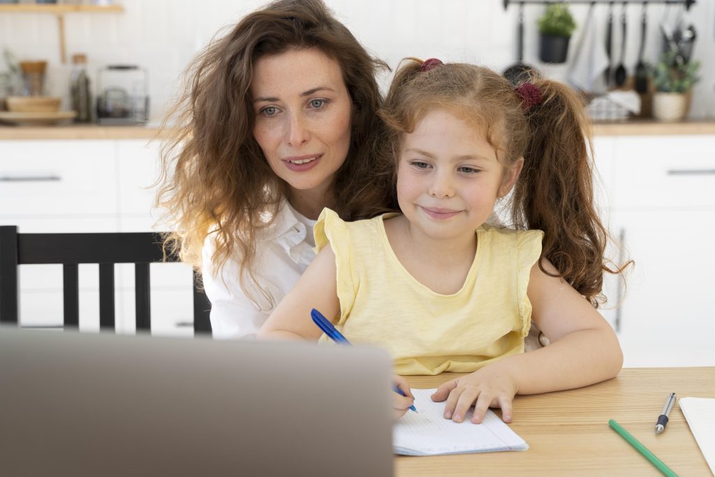 Mother and daughter learning happily on a laptop together accomodating neurodivergent learner needs..
