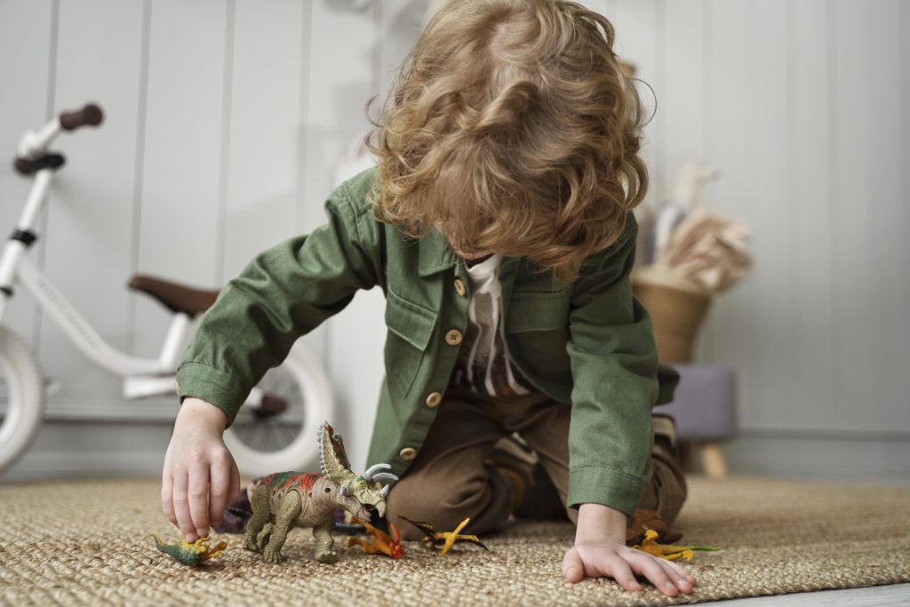 ADHD and autistic kid plays with dinosaurs