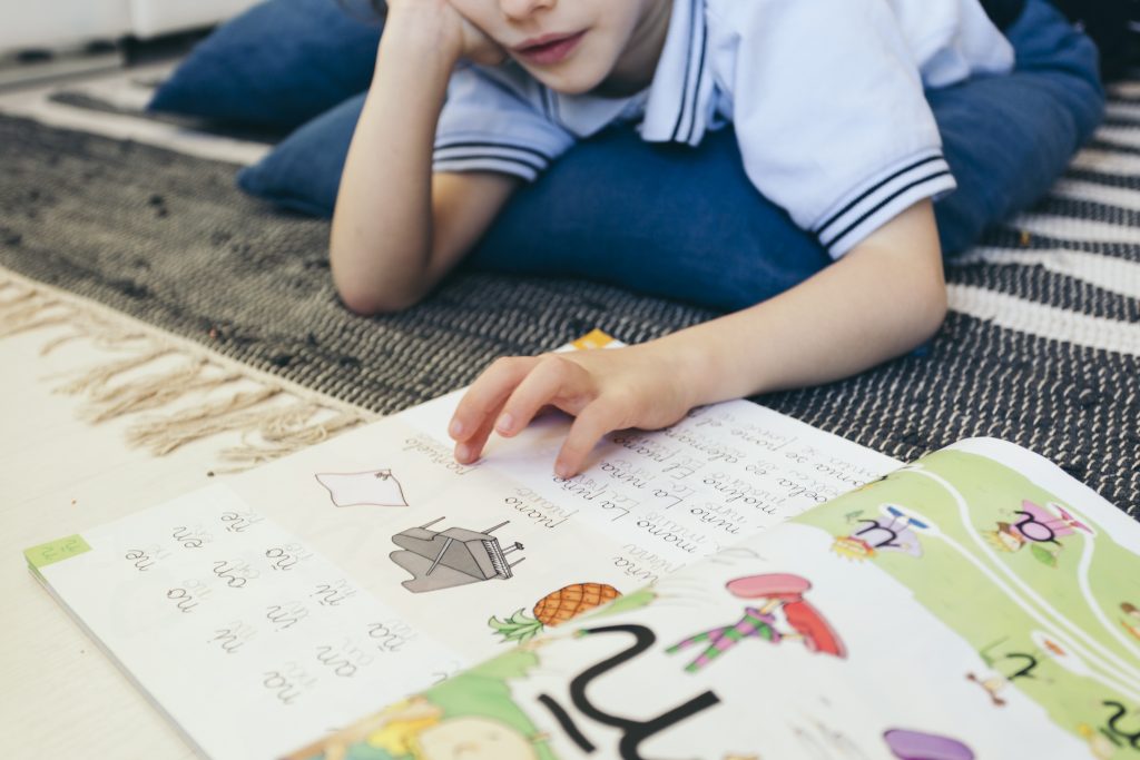 Young boy works through school workbook, executive functioning