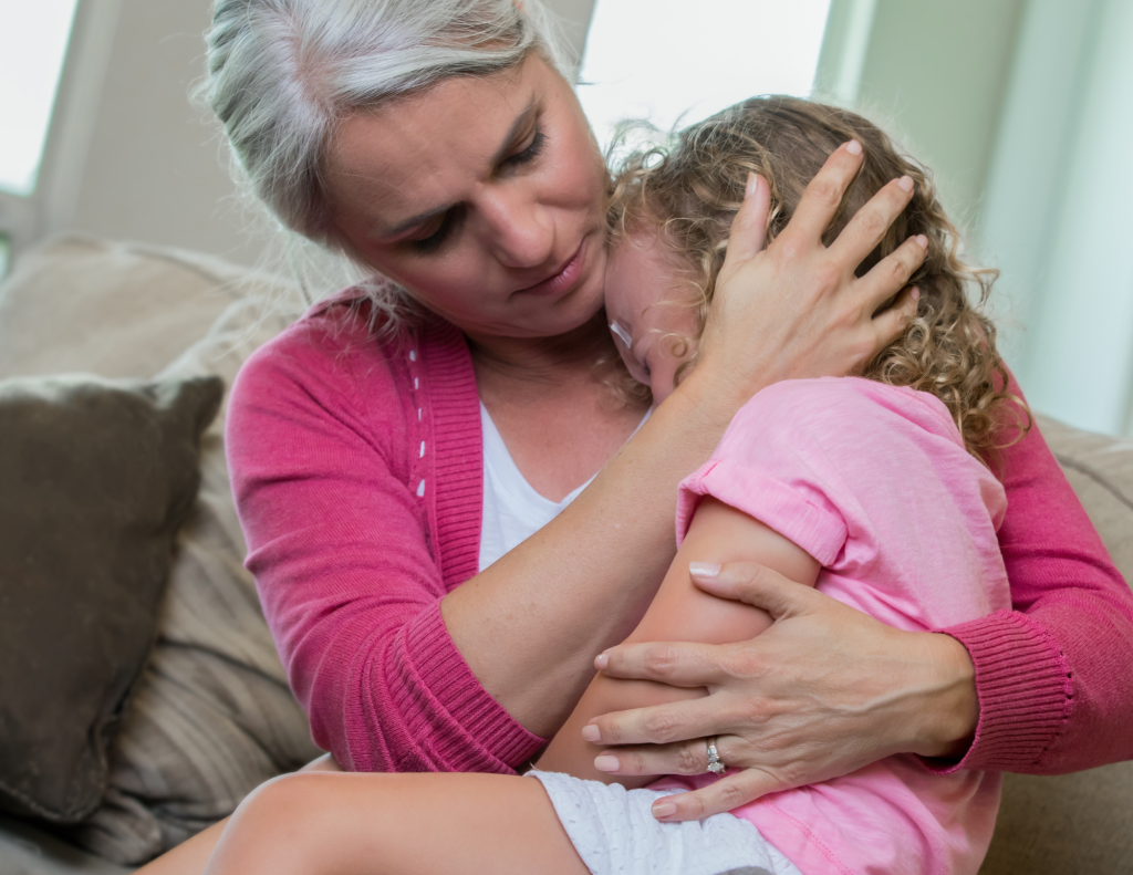Mom holds a young girl who is having a cry